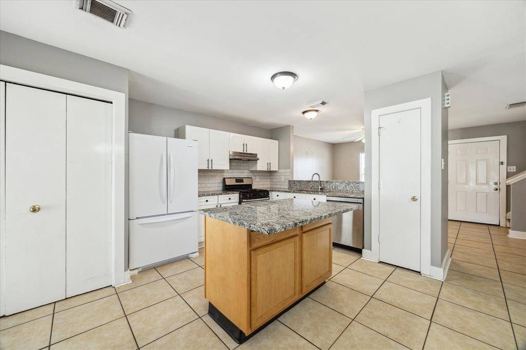 Show off your culinary skills in this spotless kitchen with granite countertops, subway tile backsplash, and a stainless steel range, hood vent, and dishwasher. You'll also find a pantry and convenient in-kitchen utility.