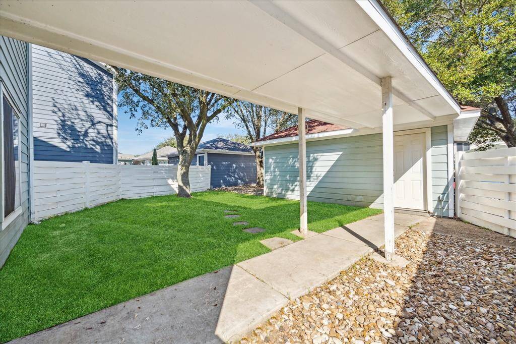 A covered breezeway connects the house to the two-car garage with convenient alley access.
