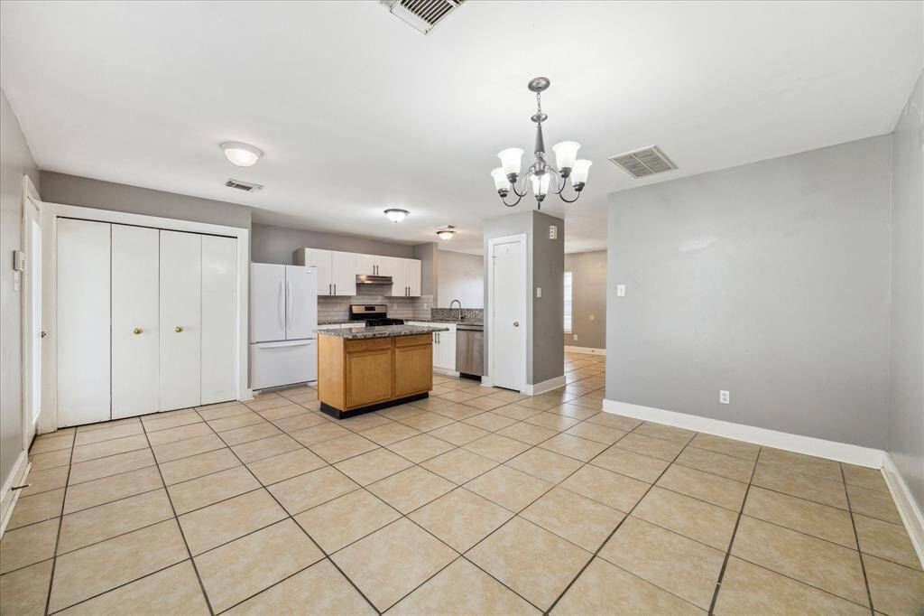 What a great flexible floor plan! Imagine your formal dining table under the chandelier and your breakfast table near the utility area. This open and inviting space is ideal for both formal and casual gatherings.