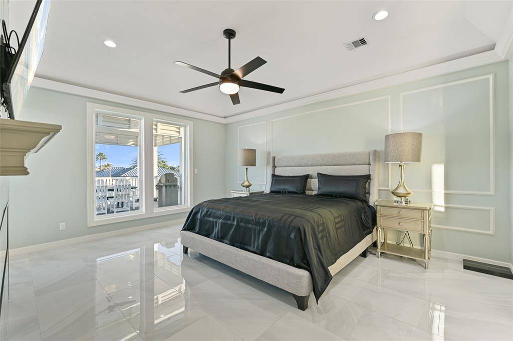 Primary suite with large picture windows providing ample natural light throughout the room