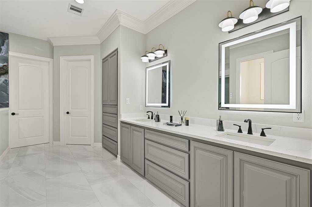 Spacious primary bath with backlit mirrors and double vanity...