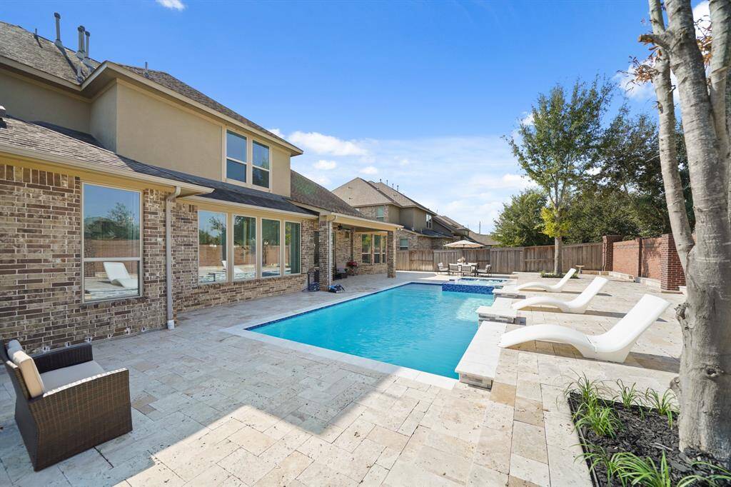 The resort style pool is expansive and luxurious, featuring an extra large design alongside a relaxing hot tub spa, creating a private oasis for leisure and rejuvenation.