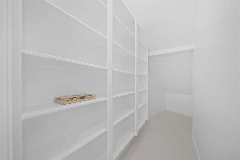 The large pantry is bright and inviting with crisp white shelves. and a sensor light that illuminates the space as soon as you step in, making it easy to find everything at a glance.