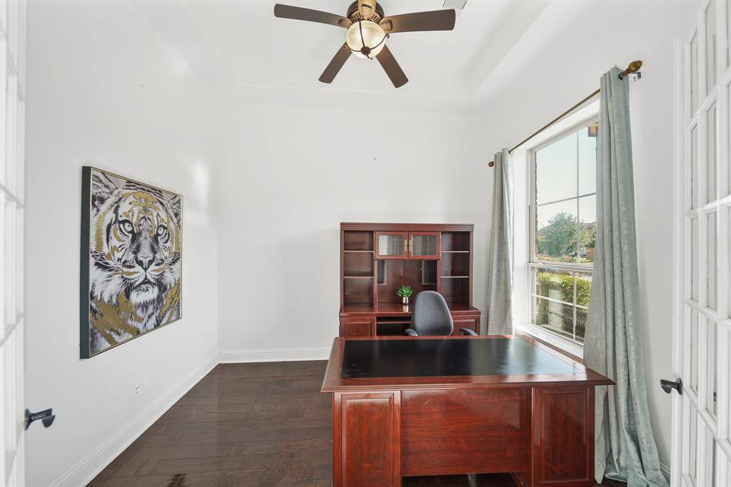 The large office is bathere in natural light, with expansive windows offering serene view. of the lush gardens, creating a peaceful and inspiring workspace or study.