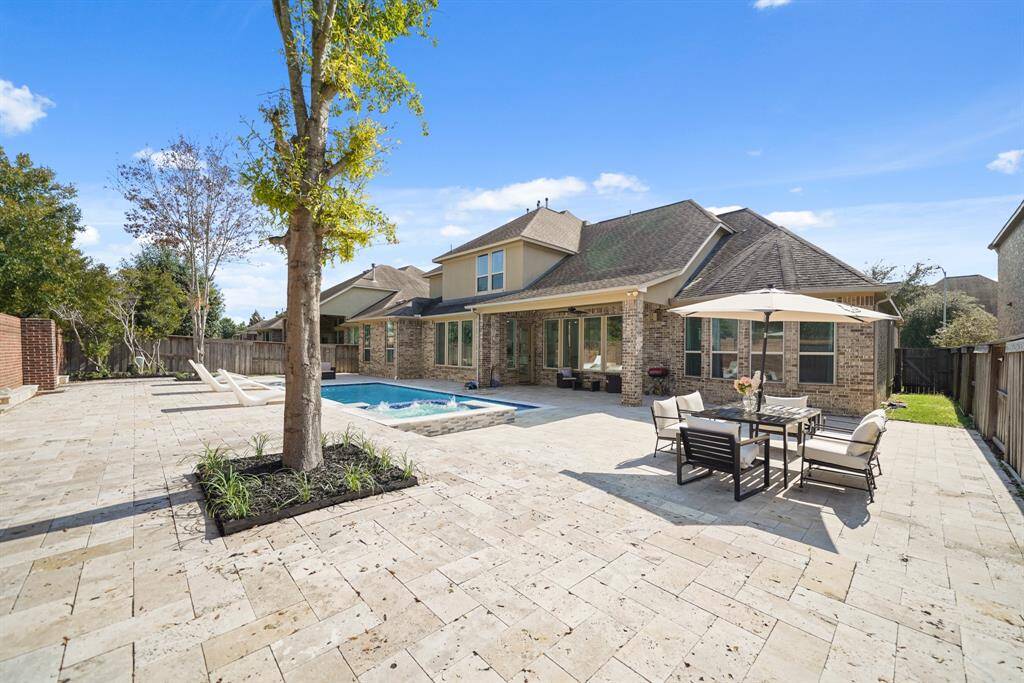 The resort style pool is expansive and luxurious, featuring an extra large design alongside a relaxing hot tub spa, creating a private oasis for leisure and rejuvenation.