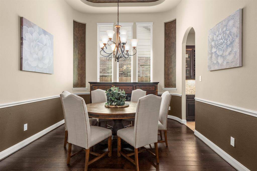Perfectly situated for entertaining, with a tiered ceiling, and a large window letting in natural light, creating a cozy atmosphere for dining with your family and guests.