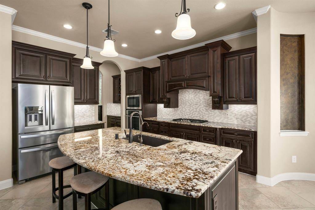 Gourmet designed kitchen showcasing premium cabinetry, sleek granite counters, and a large island create a chef’s dream.