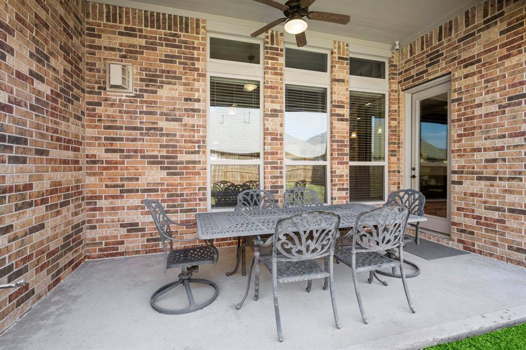 The covered patio provides a shaded space for dining, grilling, or unwinding.
