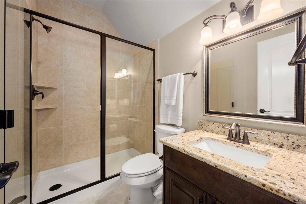 Just through the hallway you will find this full bathroom, offering a large walk-in stand up shower, granite vanity and tile flooring.