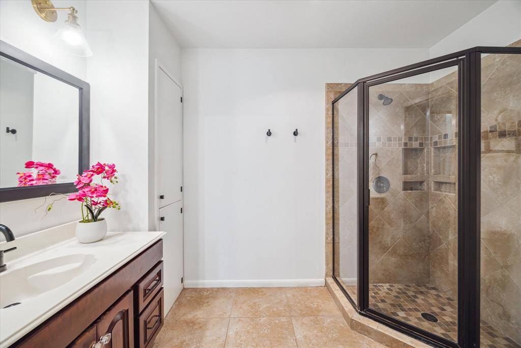 The ensuite primary bathroom offers a stand up shower, linen cabinet, and top end fixtures.