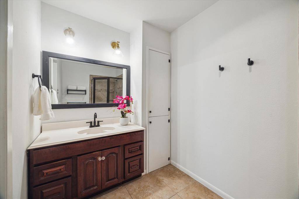 Another view of the shared sink and linen area in the primary bathroom.