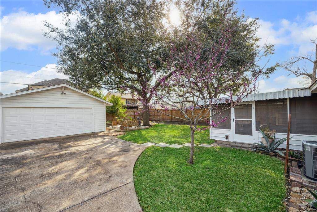 View from walking up the driveway through the private gate. You can see the large Oak tree and the Redbud tree that is starting to bloom!