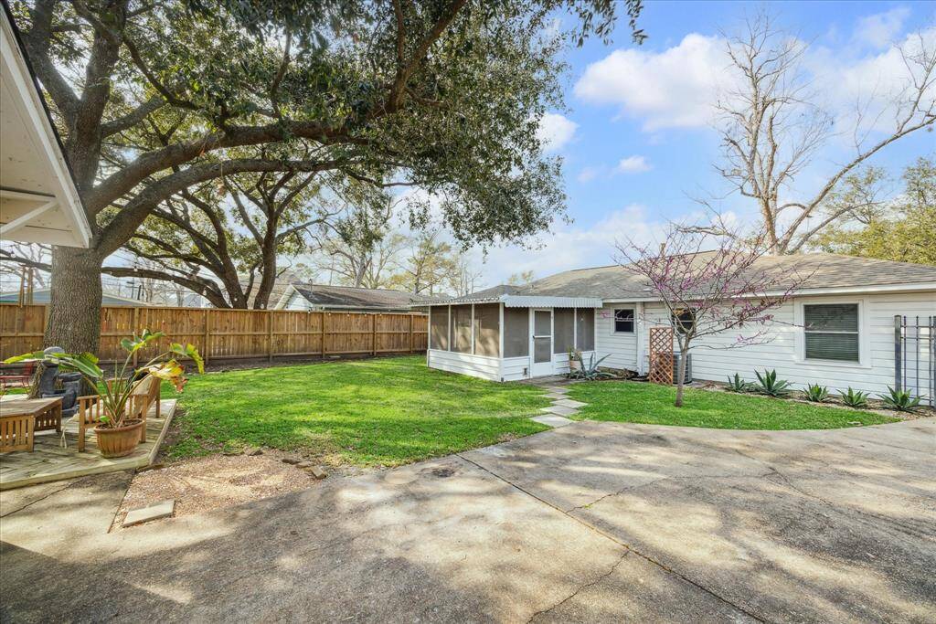This view shows the large backyard, driveway and private gate.
