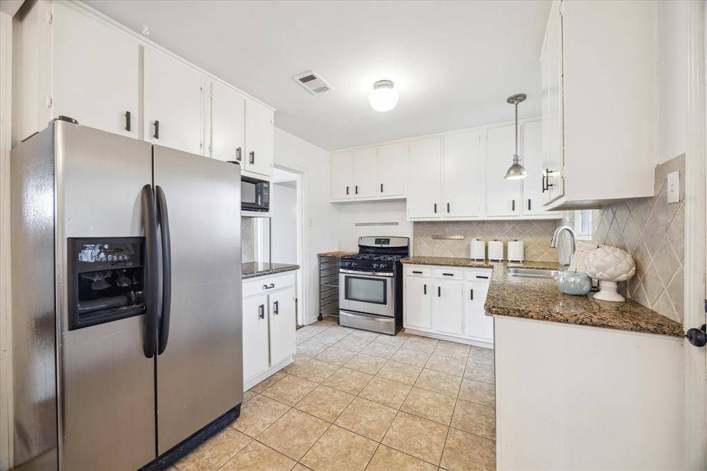 The kitchen provides ample shelves for storage space, granite countertops and stainless steel appliances. Refrigerator conveys with home.