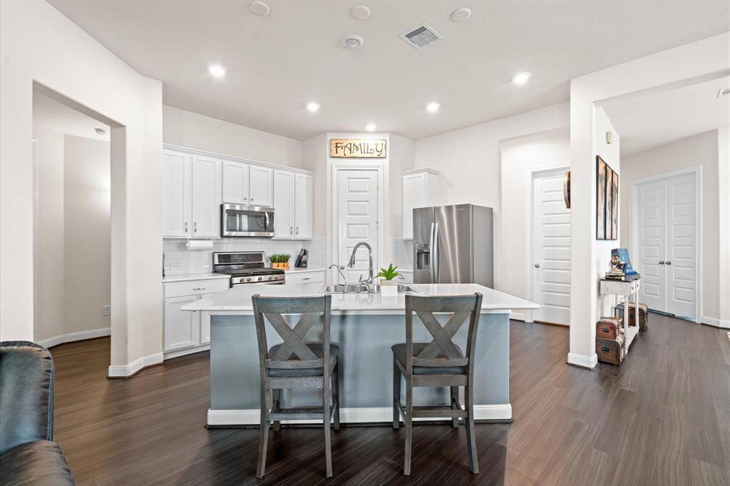 Gorgeous wood laminate flooring runs continuously throughout all the gathering spaces to create a lovely fluid home perfect for entertaining. This centrally located island kitchen opens to the family room creating a comfortable atmosphere for all.