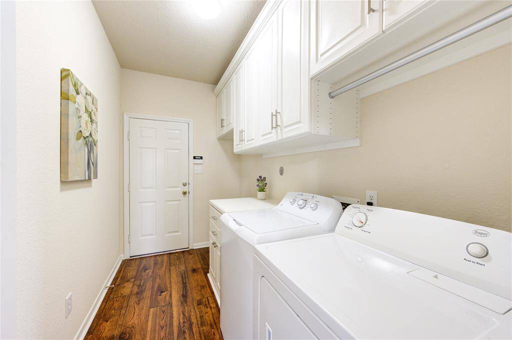 Spacious laundry room with custom cabinets for your organizational needs!