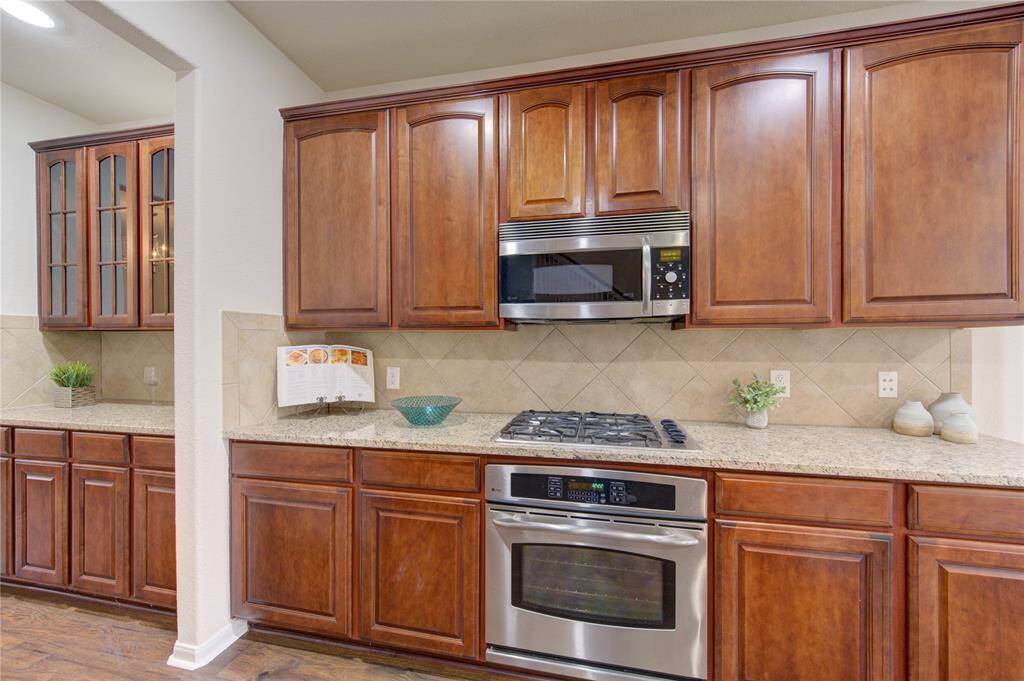 Cooking is a breeze with loads of prep space and an amazing layout. A tile backsplash and complementary granite countertops give a cohesive feel in this kitchen.
