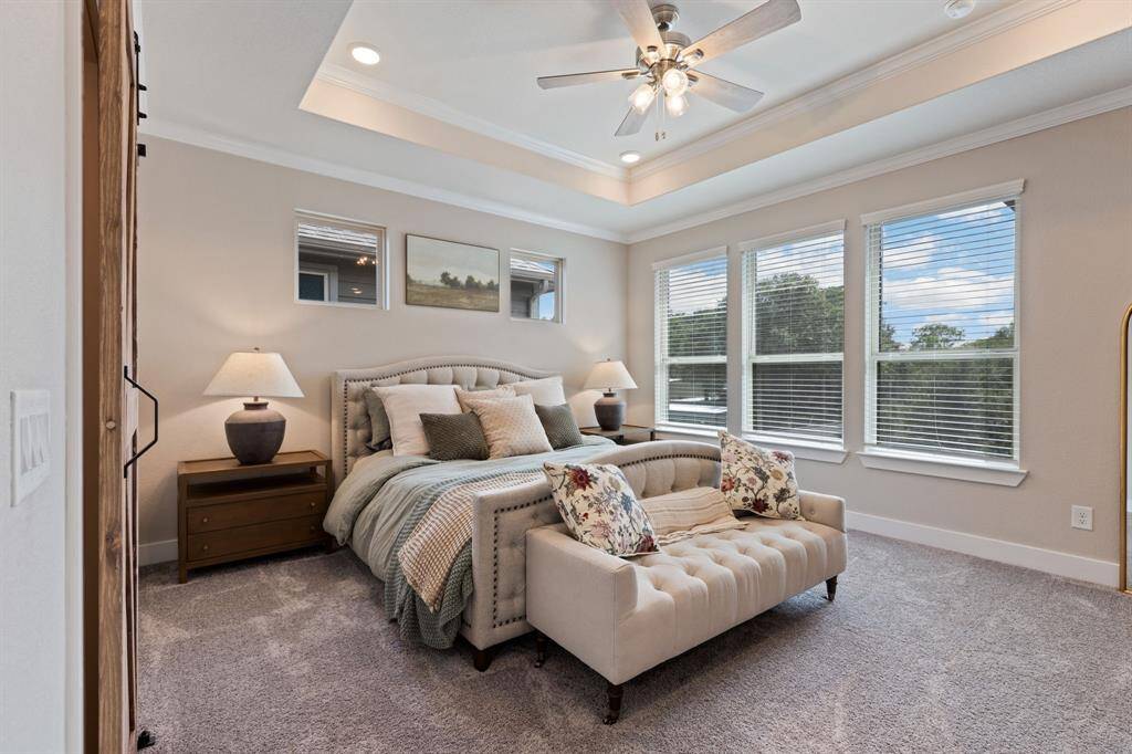 Primary Suite with Tray celing, upgraded ceiling fan.  Wall of big beautiful windows for serene views! New carpet installed in all rooms August 8th.