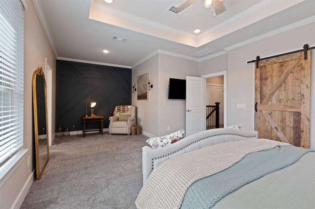 Primary Suite with beautiful accent wall on the nice sized sitting area.  Great for reading area, extra desk, workout equipement so many possibilties!  Barn door opens to big closet with custom cabinets.