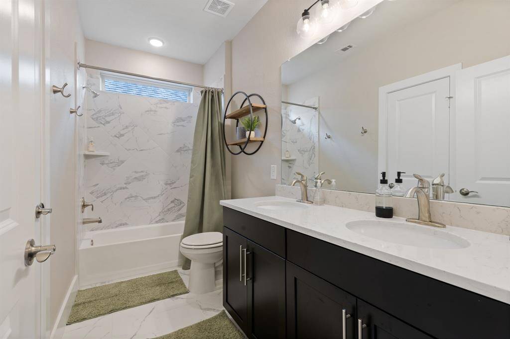 Secondary bathroom upstairs. Home has energy efficient tankless water heater.