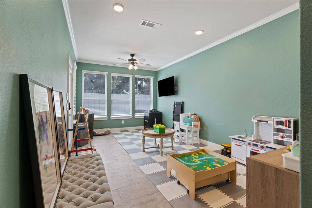 Huge first floor living or game room with crown molding.  Currently a playroom could be second living area for a toom mate or in-law suite.    Has it's own bedroom and bathroom and private patio.