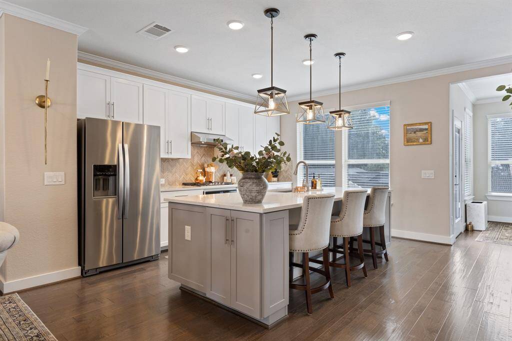 Kitchen is a chefs dream. A huge island, tons of storage, quartz countertops, designer light fixtures, gas cook top, recessed lighting, beautiful wood flooring and a custom designed pantry. All with views to one of 3 large outdoor living spaces. The entire home has been freshly painted. Double pane windows and and tankless water heater.