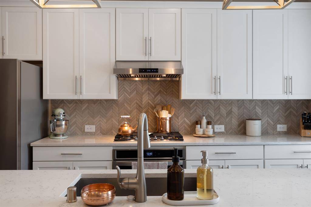 Beautiful finishes.   Herringbone back splash, oversized island, nice big farm sink, quartz countertops, upgraded vent hood & garbage disposal.