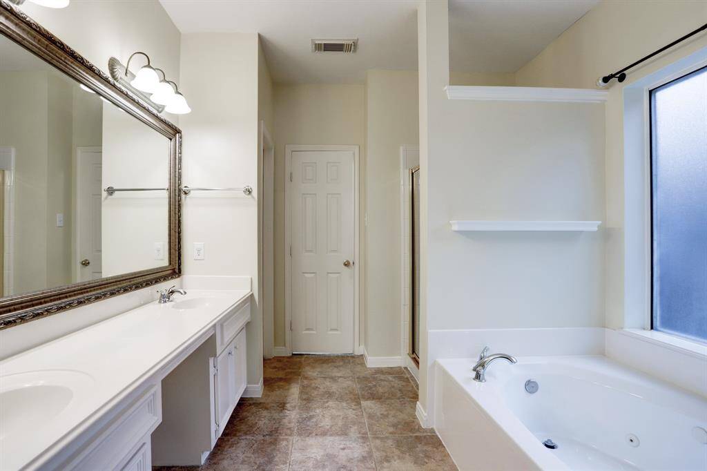 The primary bath has tile flooring and ample space between the two sinks.