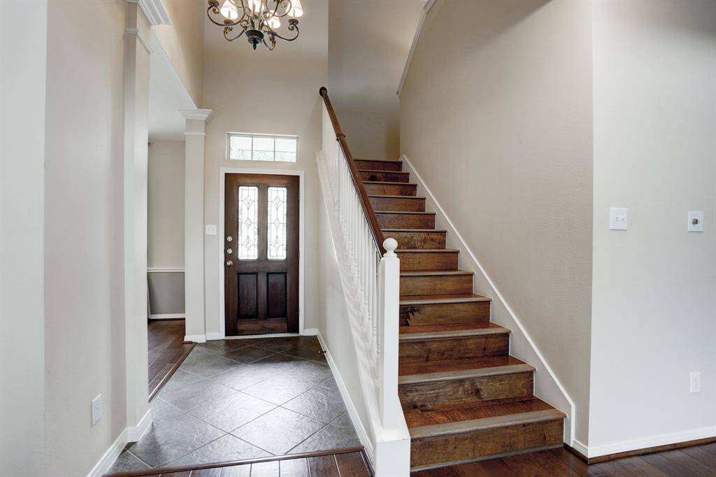 Tile flooring in the two story entrance with engineered wood on the stairway