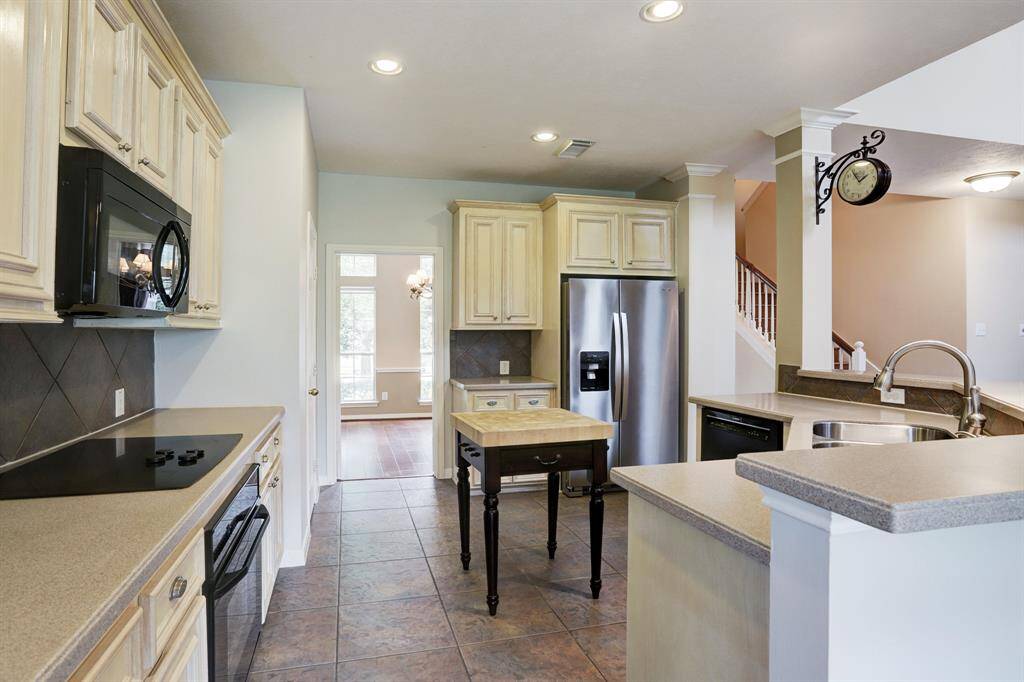 The kitchen has solid surface polymer countertops, tile flooring and backsplash plus stainless appliance including the refrigerator.