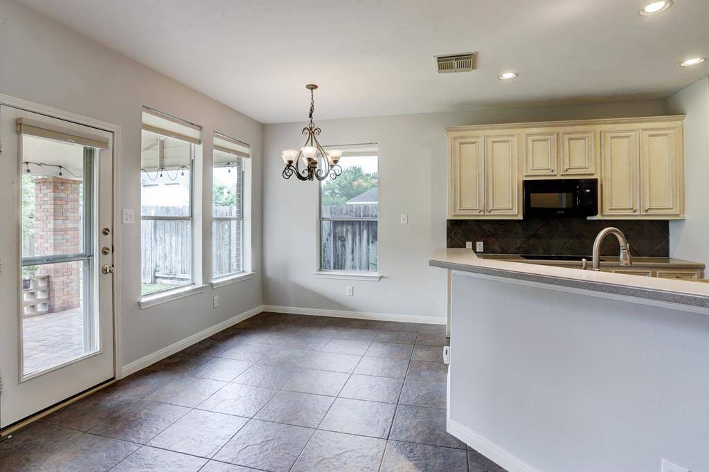 The breakfast area has tile flooring and opens to the covered patio.