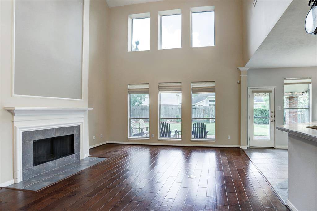 The main living area has a full two story ceiling, engineered wood flooring, a fireplace and windows overlooking the back yard.