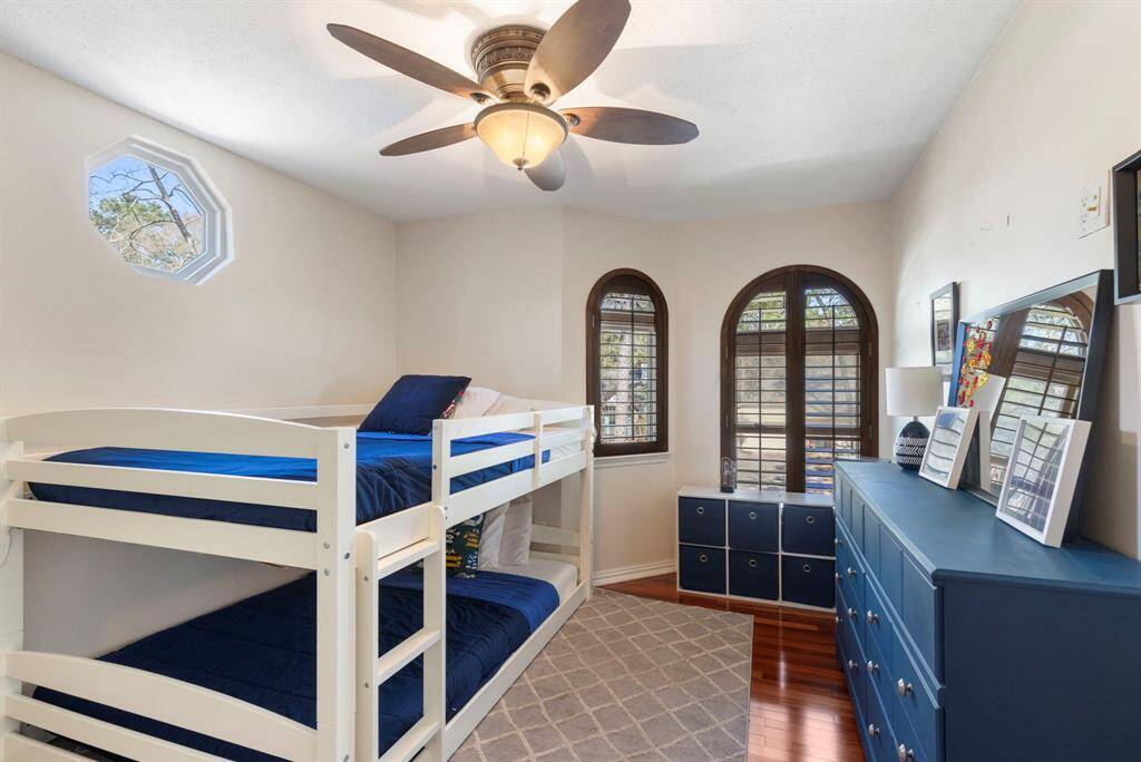 Secondary bedroom upstairs, with wood flooring and plantation shutters.
