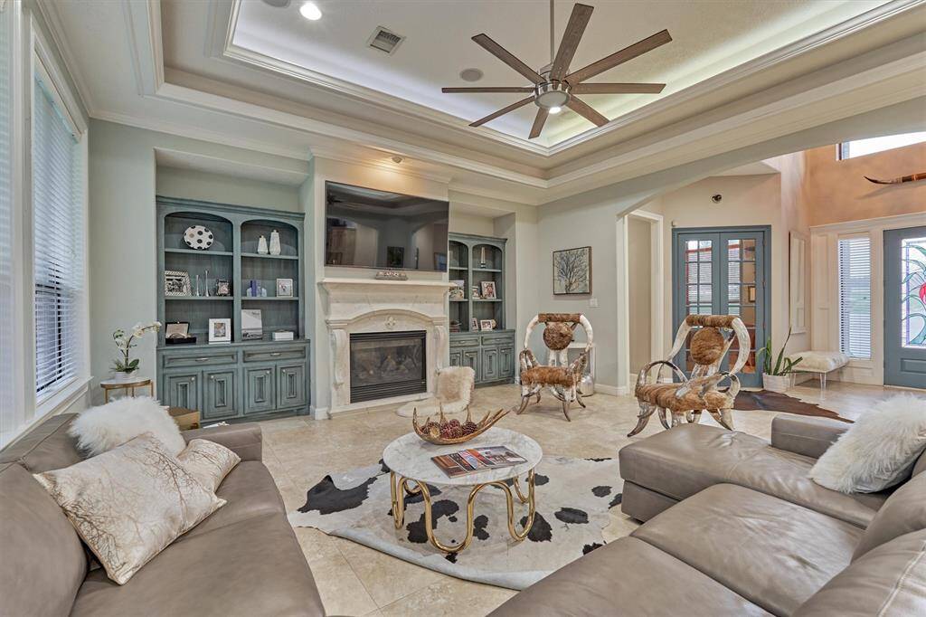 The living room has a lighted tray ceiling, is wired for surround sound, and has a remote controlled gas log fireplace.