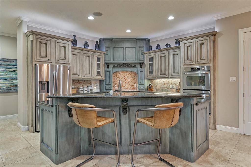The custom painted cabinets provide a unique touch! The food/butlers pantry is situated behind double doors to right.