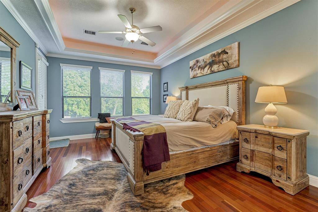 The primary bedroom offers a welcome respite! You’ll notice the hardwood floors and tray ceiling with ambient lighting.