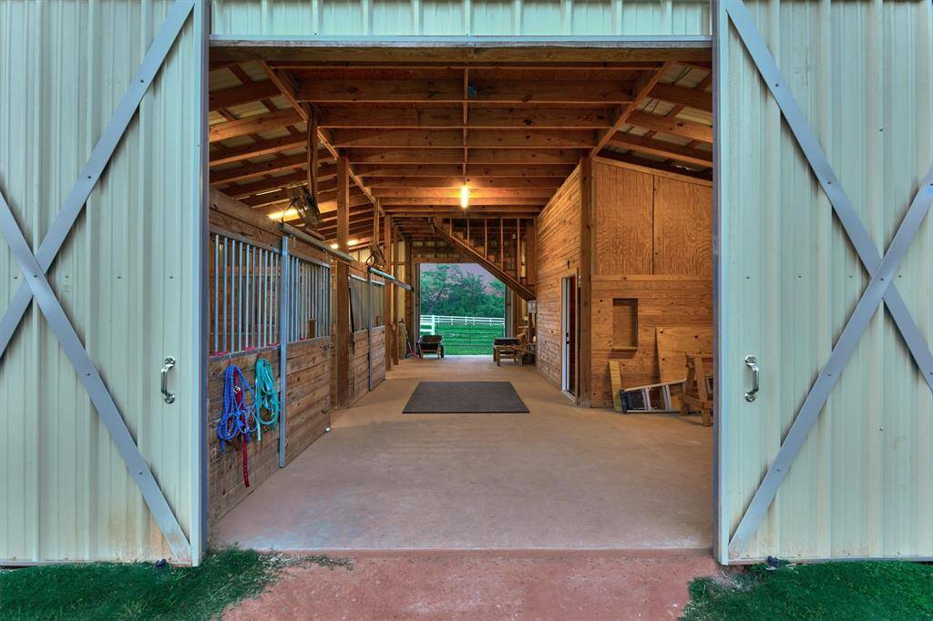 The barn features three 12 x 12 stalls with turnouts, a wash rack, and tack room with loft.