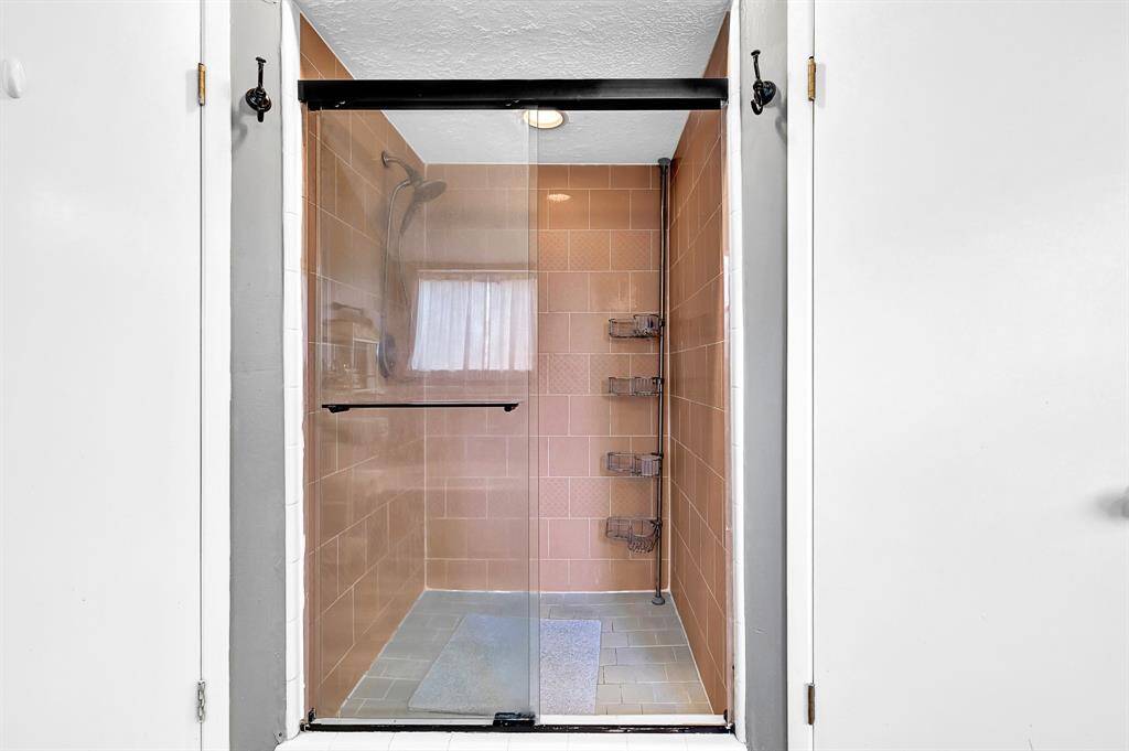 Large walk-in, shower with glass doors.