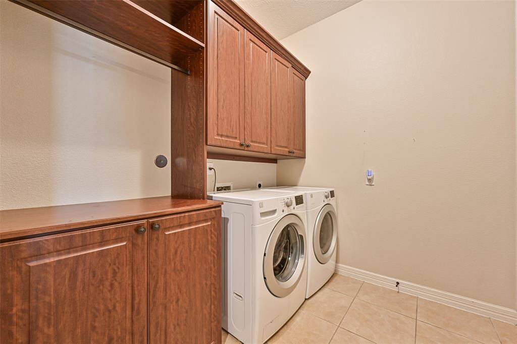 In house Utility Room with storage cabinets, clothes hanging and folding space
