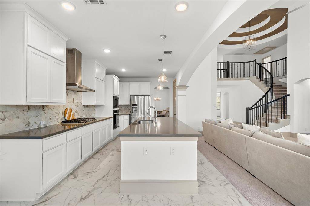 The well-appointed kitchen boasts a vast island with counter seating and tons of built-in storage—offering quick meal preparations.