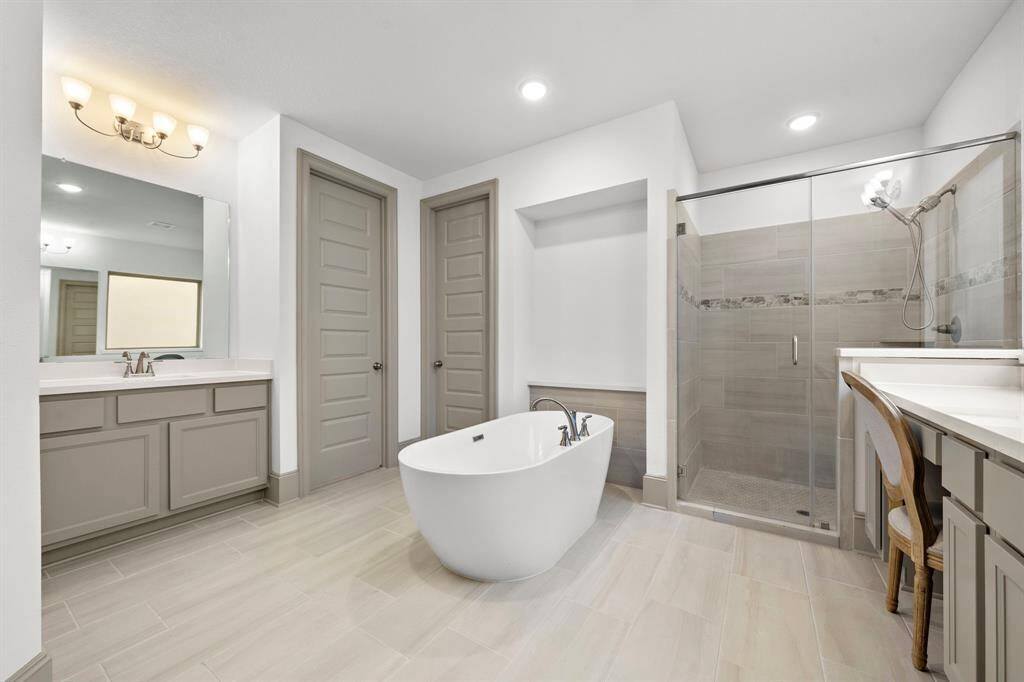 Bathed in natural light, the primary bedroom offers a spacious retreat with a beautifully crafted tray ceiling and large bay windows overlooking the backyard.