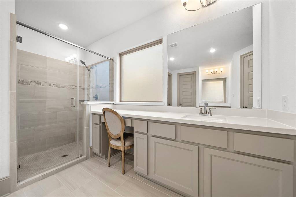 The centerpiece of this luxurious ensuite is a freestanding soaking tub, thoughtfully positioned to create a spa-like retreat for relaxation and rejuvenation.
