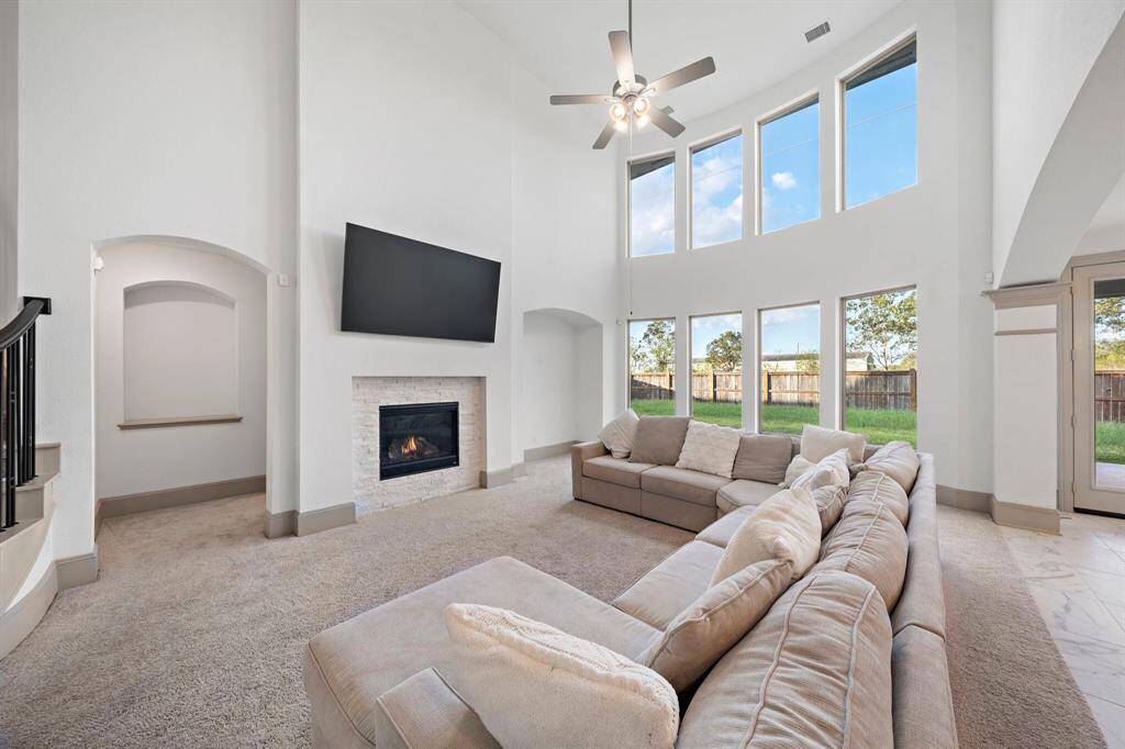 Natural light pours into the first-floor living area with soaring ceilings and a stylish fireplace with modern stone surround. Delight in sophisticated entertainment, thanks to the seamless flow between the open living area, kitchen, and breakfast nook.