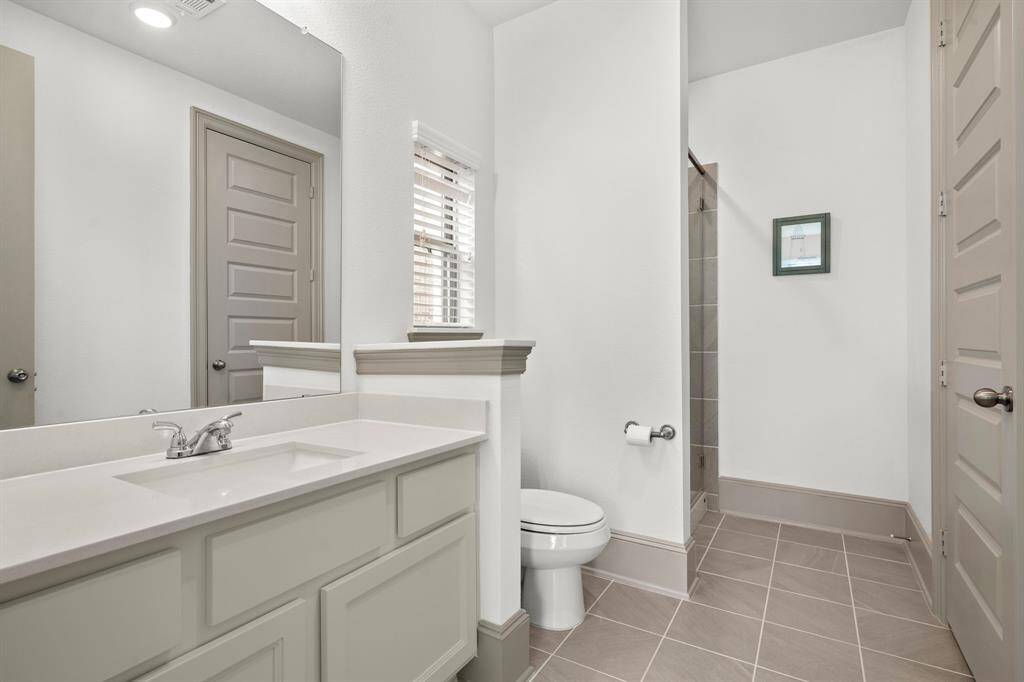 This first-floor secondary bedroom offers versatility with ample space and natural light, making it ideal for customization as a guest suite, home office, or private retreat. This photo has been virtually staged.