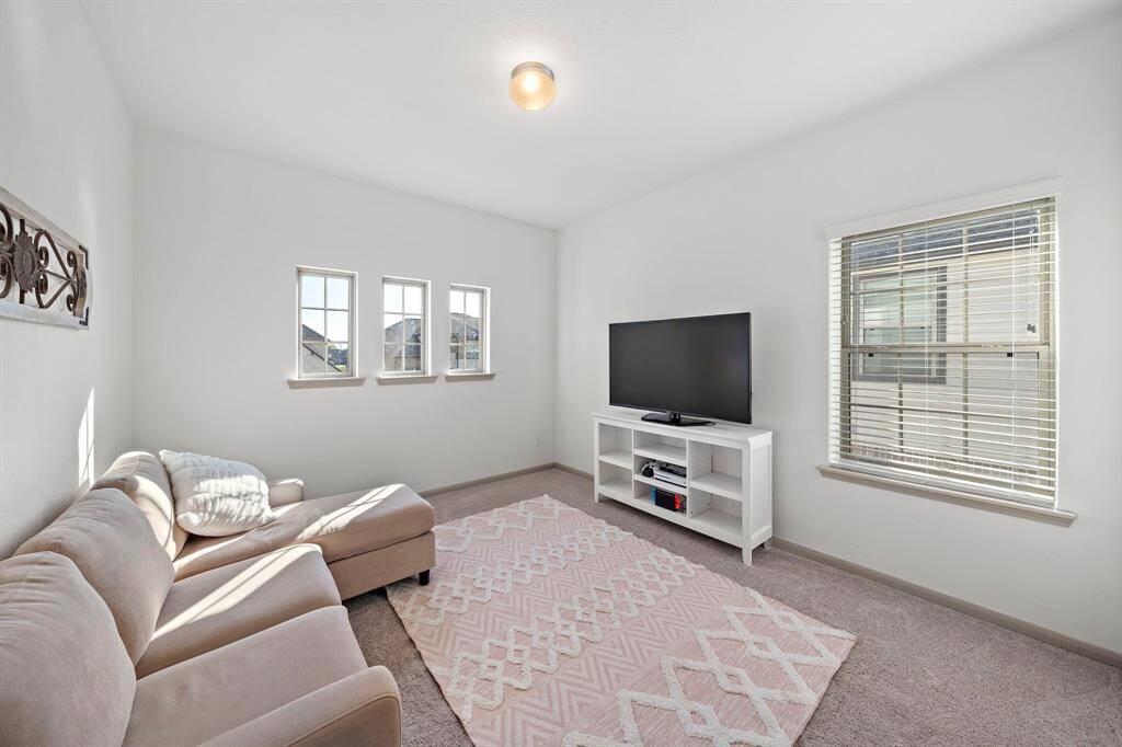 With its vaulted ceilings and ample natural light, this secondary bedroom easily accommodates various layouts, making it an ideal space for guests. This photo has been virtually staged.