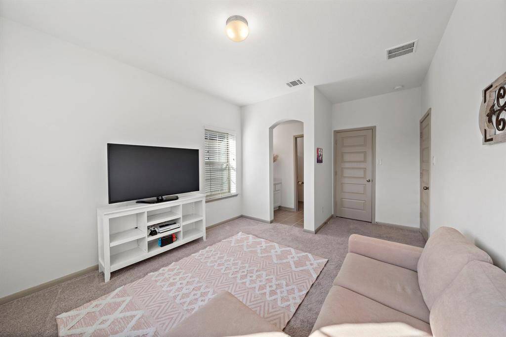 This secondary bedroom provides a versatile space with multiple windows that fill the room with natural light.