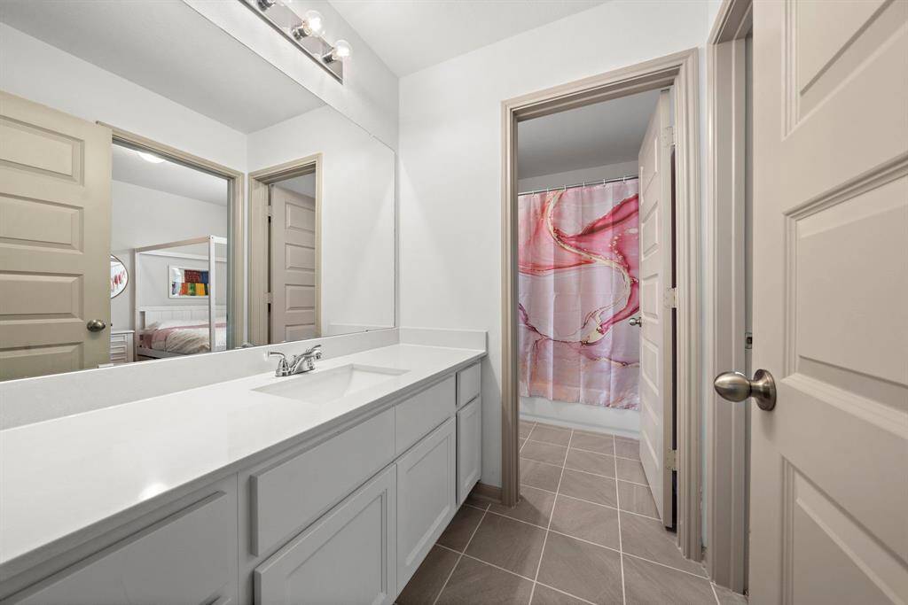 The Hollywood bath offers a functional and stylish design, featuring a wide vanity with ample counter space and sleek fixtures. Its clever layout connects seamlessly to adjoining rooms, ensuring convenience for shared use.
