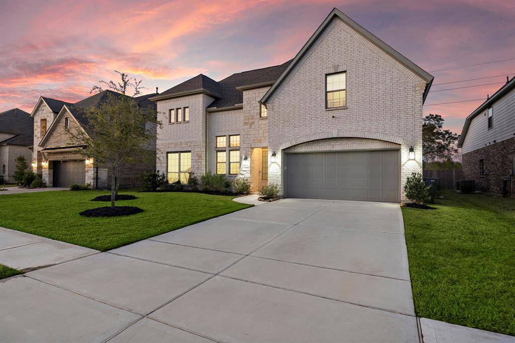 Showcasing undeniable curb appeal, this home's striking exterior combines elegant brickwork, thoughtfully manicured landscaping, and a warmly lit entryway that welcomes you home in style.