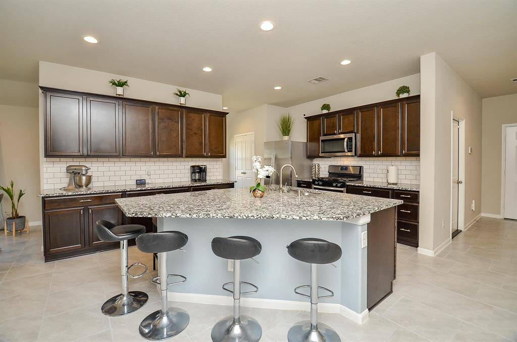 A well-designed kitchen with ample cabinet space, a large island for extra seating and prep space, and plenty of room for cooking and storage.