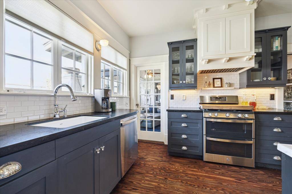 This view shows the abundant counter space, large undermounted farmhouse style sink and how perfectly each prep area is designed.